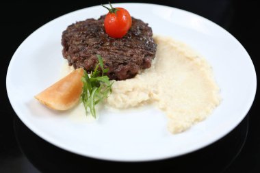 kızarmış et pirzola ile kereviz püresi, domates ile süslenmiş bir tabakta izole kiraz ve ekşi elma,