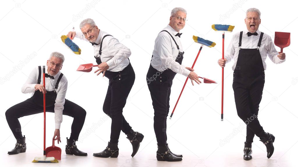 Gray-haired cleaner, janitor in a black jumpsuit with a mop and dustpan provides cleaning service, on white background
