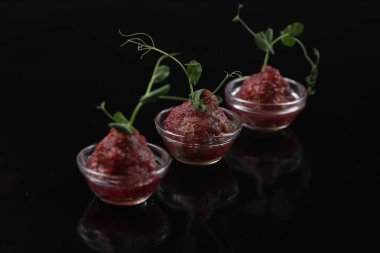 Üç pialas, kırmızı iştah açıcı Remoulade dekore edilmiş filizlenmiş yeşil bezelye, bir kök ile yakın çekim