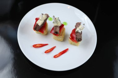 et bir rulo devirdi, dilimlenmiş kanepeler mavi peynir ve bir şiş üzerinde kırmızı biber ile yakın çekim