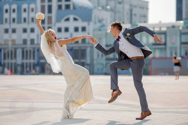 Novia y novio en traje de novia bailando ardiente danza en la plaza de la ciudad Imágenes de stock libres de derechos
