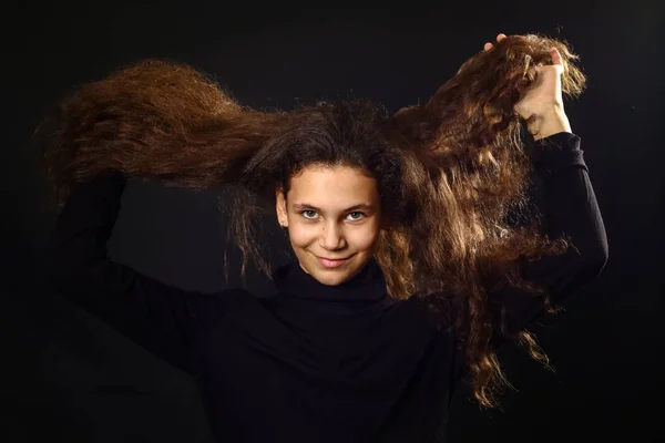 Retrato emocional de una chica con el pelo largo y rizado en el fondo Imágenes de stock libres de derechos