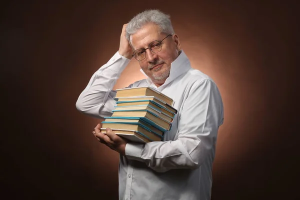 Pensador científico, filosofía, anciano hombre de pelo gris en una camisa blanca con libros, con luz de estudio Fotos de stock libres de derechos
