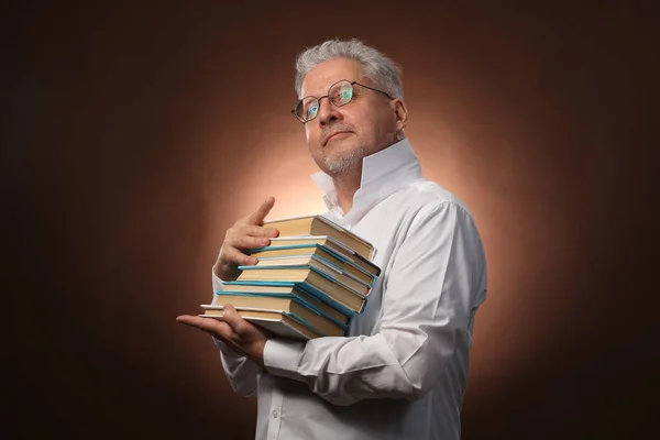 Pensador científico, filosofía, anciano hombre de pelo gris en una camisa blanca con libros, con luz de estudio Fotos de stock libres de derechos