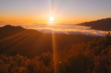 Dağların üzerinde gün batımı bulutların üzerinde