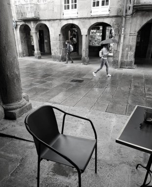 Eski caddeli bir kafe ve yağmurlu günlerde şemsiyeli bir kız.