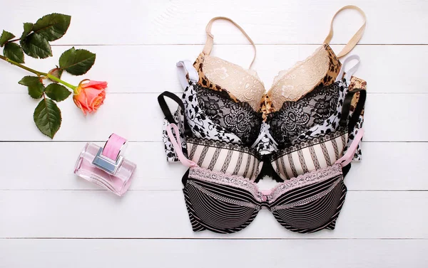 güzel seksi sütyen ve ahşap arka plan üzerinde parfüm