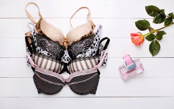 güzel seksi sütyen ve ahşap arka plan üzerinde parfüm