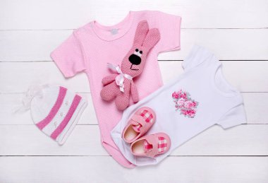 Beyaz arka plan üzerinde yeni doğmuş kız bebek giysileri