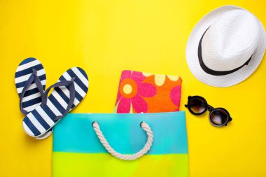 Sarı bir arka plan üzerinde şık plaj aksesuarları