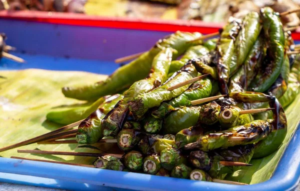 Çubuklu ızgara yeşil biber Chiangmai 'deki markette plastik tepsiye konur..