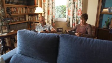 Yaşlı çiftlerin, dedelerin, eski koltuklarda oturup cep telefonu ve tabletlere bakarken çekilen tüm görüntüleri. Kırsal ve iyi dekore edilmiş bir evin oturma odasında..