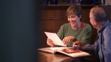 Sevgili son sınıf çifti eski düğün albümlerine bakıyor. Geçmişi hatırlamak. Olgun bir aşk. İçeride, gündüz vakti..