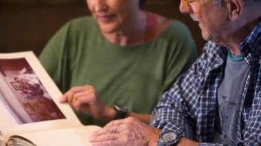 Sevgili son sınıf çifti eski düğün albümlerine bakıyor. Geçmişi hatırlamak. Olgun bir aşk. İçeride, gündüz vakti..