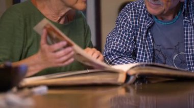 Sevgili büyükanne ve büyükbabalar eski düğün albümlerine bakarlar. Geçmişi hatırlamak. Olgun bir aşk. İçeride, gündüz vakti..