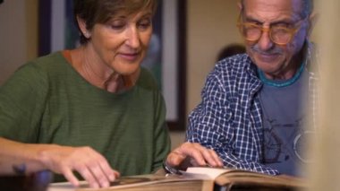 Sevgili büyükanne ve büyükbabalar eski düğün albümlerine bakarlar. Geçmişi hatırlamak. Olgun bir aşk. İçeride, gündüz vakti..