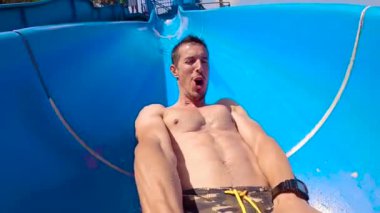 40 'lı yaşlarda, beyaz bir adamın su parkından kayarken yavaş çekim görüntüsü..