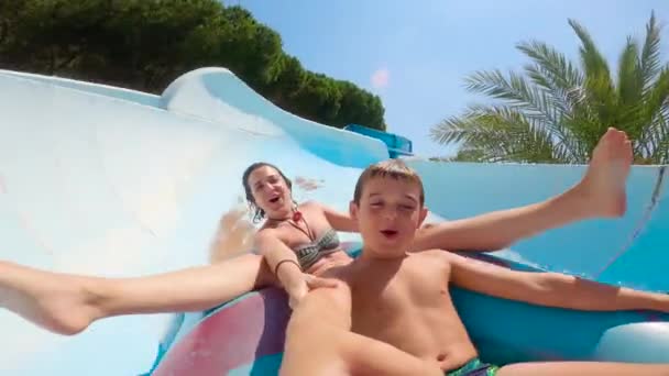 儿子和母亲自私自利 在橡皮圈上滑水 暑假期间在水上游乐园滑行 — 图库视频影像