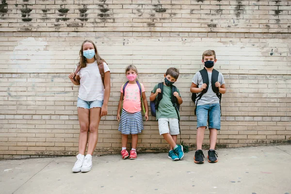 Crianças Caucasianas Diferentes Idades Com Máscaras Protetoras Mochilas Olhando Para — Fotografia de Stock