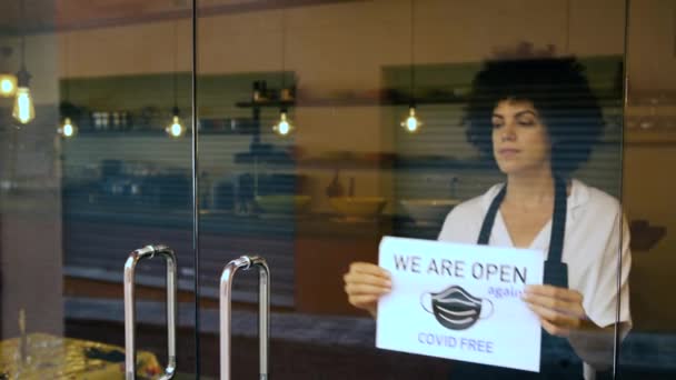 Усміхнена Офіціантка Дивлячись Камеру Вивішує Знак Відкритий Вхідних Дверях Після — стокове відео