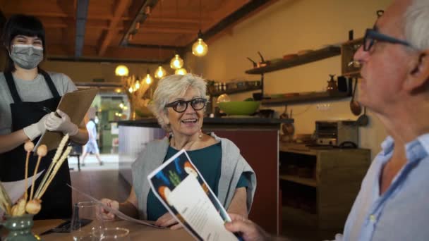 Ellerinde Menüyle Masada Oturan Yaşlı Çift Restoranda Yemek Siparişi Veriyor — Stok video