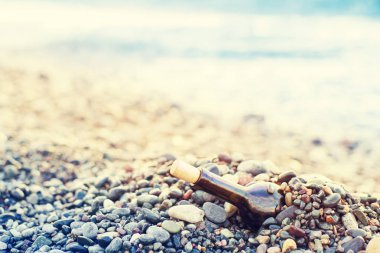 Sahil, yumuşak odak, boş şarap şişesinde tonda