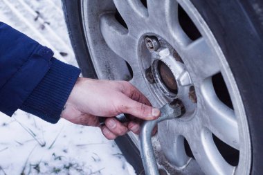 Kışın karda değiştirme tekerlek, yakın çekim. Kış lastik değişimi