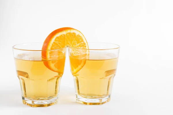 Один Апельсиновий Шматочок Поєднує Дві Склянки Соком Світлій Поверхні Концептуальний — стокове фото