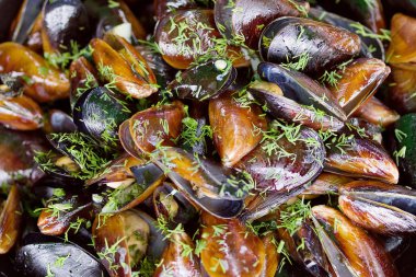 Bir plaka üzerinde yeşillikler ile pişmiş midye, deniz ürünleri, yumuşak odak