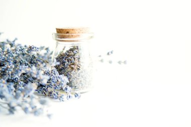 Beyaz arka plan, yumuşak odak üzerinde lavanta ile kurutulmuş lavanta çiçekleri ve buket ile Cam şişe