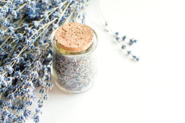 Beyaz arka plan, yumuşak odak üzerinde lavanta ile kurutulmuş lavanta çiçekleri ve buket ile Cam şişe