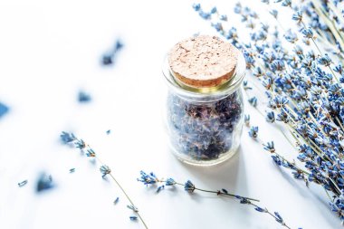 Beyaz arka plan, yumuşak odak üzerinde lavanta ile kurutulmuş lavanta çiçekleri ve buket ile Cam şişe