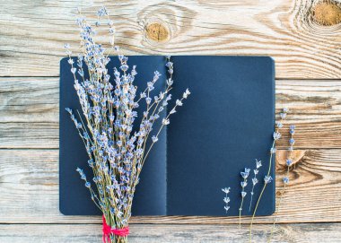 Eski ahşap arka plan üzerinde metin ve buket kurutulmuş lavanta çiçekleri için boşluk ile Siyah sketchbook