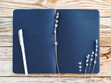 Eski ahşap arka plan üzerinde metin ve kurutulmuş lavanta çiçekleri için boşluk ile Siyah sketchbook