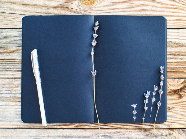 Eski ahşap arka plan üzerinde metin ve kurutulmuş lavanta çiçekleri için boşluk ile Siyah sketchbook