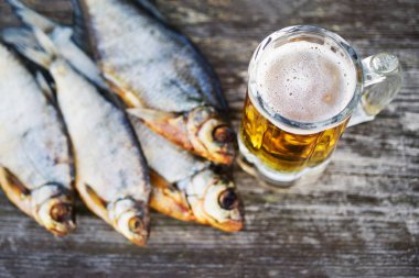 Birbardak bira, eski tahta bir masada tuzlu balık, yumuşak odak. Bira ve aperatif bira.