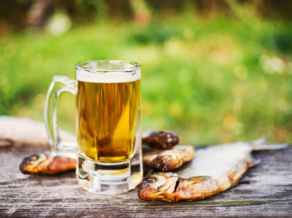 Glass of beer, salty fish on an old wooden table, soft focus. Beer and snack to beer.