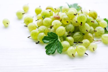 Beyaz ahşap bir arka planda bektaşi üzümünün sulu meyveleri. Yaz meyveleri