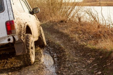 Kirli SUV su birikintileri ve kirli yakın çekimle off-road yapıyor. Off-road seyahati