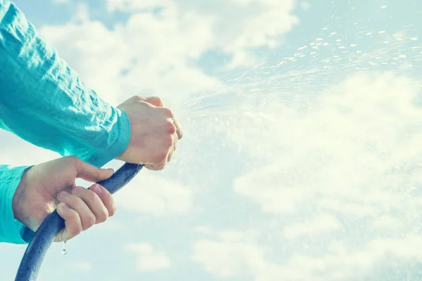 Handen Van Het Kind Houden Een Slang Met Water Tegen — Stockfoto