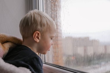 Pencerenin dışında yağmurlu bulutlu hava, su damlalarının üzerinde