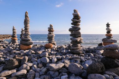 Farklı boyutlarda taşlar ve dengeyi koru. Piramitler mavi gökyüzüne karşı duruyor