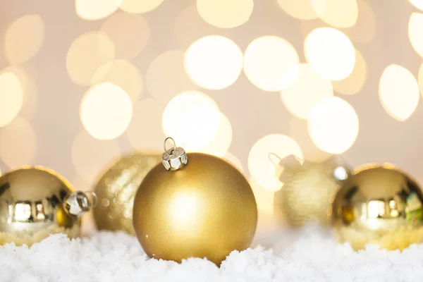 Palline Natale Oro Sulla Neve Sfondo Luci Albero — Foto Stock