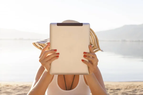 Flicka med en Tablet PC på stranden — Stockfoto