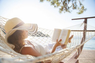 Hamaktaki kadın ve tatil kitapları.