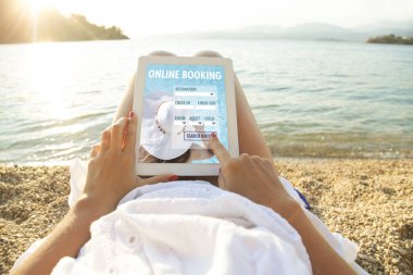 Uygulama otel rezervasyonlu tablet bilgisayarlı bir kadın.