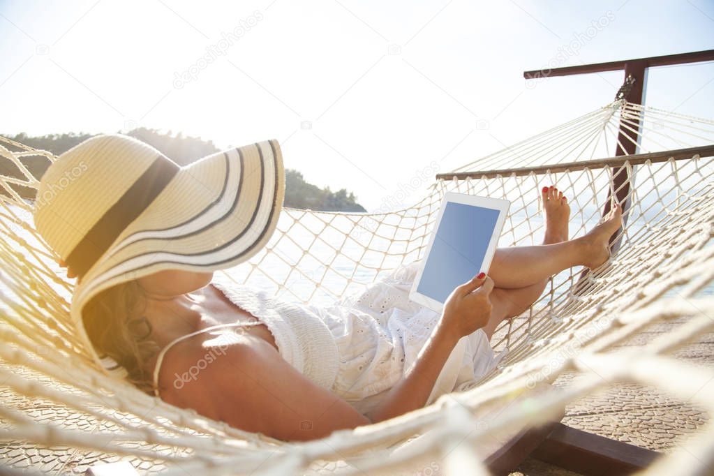 Woman using tablet pc on beach