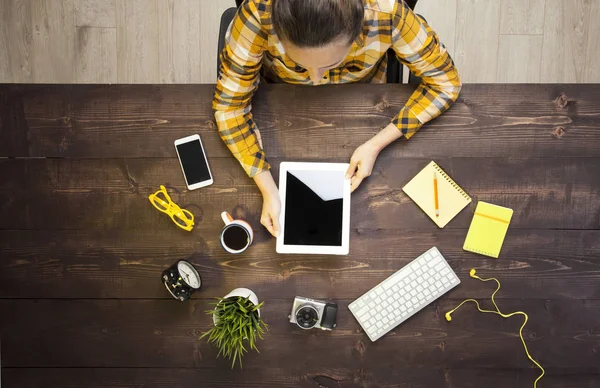 Woman holding tablet knolling overhead view — Stock Photo, Image