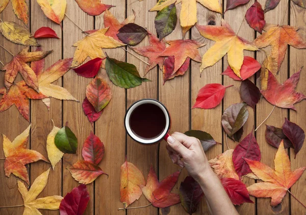 Hände mit einer Tasse Kaffee auf hölzernem Hintergrund — Stockfoto