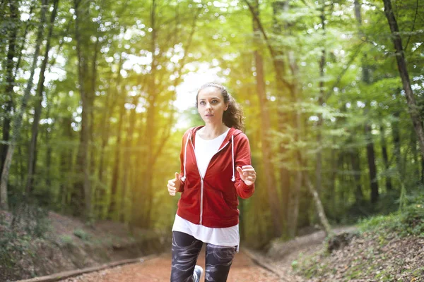 Joven mujer de fitness corriendo por el sendero forestal — Foto de Stock